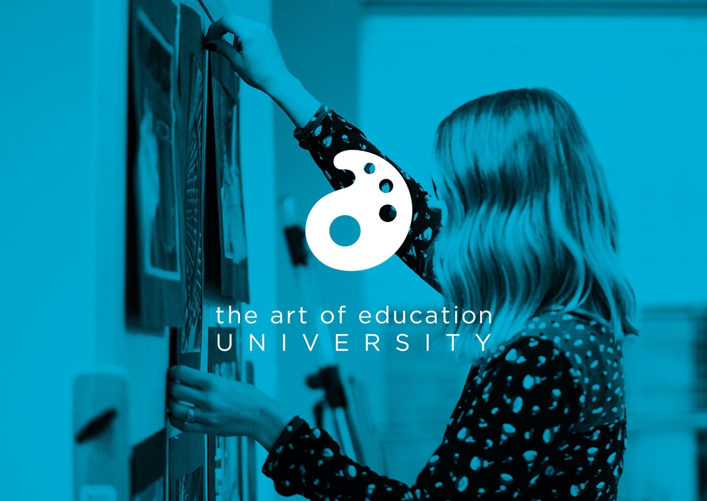 A woman adjusts artwork on a wall